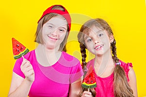 Girl Down syndrome and little girl with large Lollipop