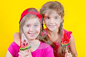 Girl Down syndrome and little girl with large Lollipop