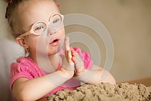 Girl with Down syndrome playing kinetic sand photo