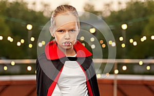 girl in dracula costume with cape on halloween