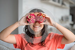 Girl and dragon fruit. Joyful girl enjoying tropical fruits