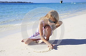 Girl drawing in beach sand