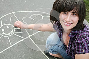 Girl drawing a chalk on asphalt