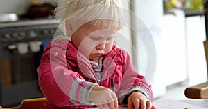 Girl drawing with crayon on a paper at home 4k