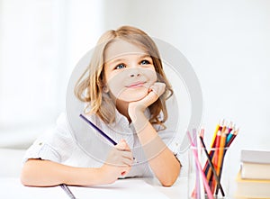 Girl drawing with pencils at school