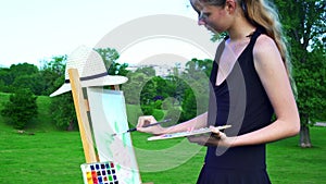 Girl draws on plein air city park mountain background