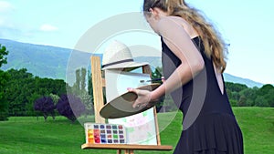 Girl draws on plein air city park mountain background