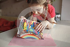Girl draws rainbow with melted crayon pencils, she using blow dryer and wax stars to melt, art idea