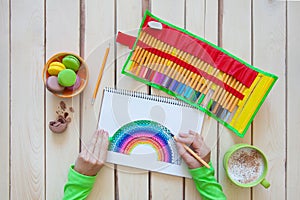 Girl draws a rainbow. Positive drawing. Art therapy and relaxation.