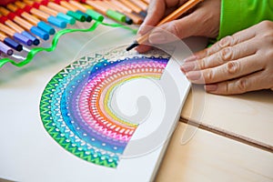 Girl draws a rainbow. Positive drawing. Art therapy and relaxation.