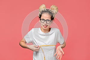 Girl with dreads in a white shirt and glasses looking is upset measuring her boobs