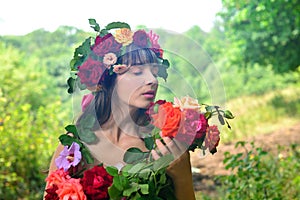 Girl in a dress of color sniffs roses