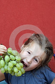 Girl with dress eating white grapes