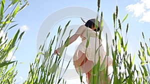 Girl in a dress in a field of green grass. Girl lifestyle sunlight glare sun, summer happiness