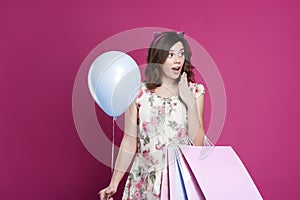 Girl in dress with gift bags and balloon