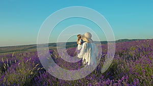 Girl in a dress goes to her mom in a flowering lavender field