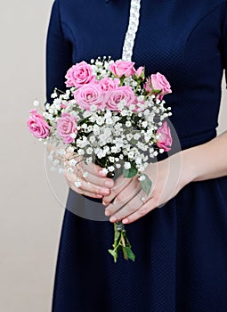 The girl in the dress holding a bouquet of roses