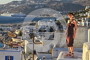 Girl in dress with Mykonos town, Greece