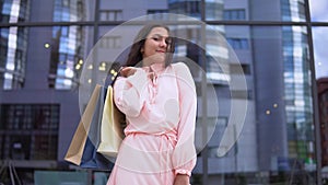 Girl in a dress after shopping with bags in hands. 4K