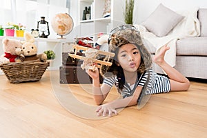 Girl dress up as aviator lying down on floor