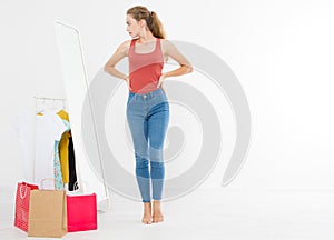 Girl dress up and looking in mirror. Shopping and weight loss concept. Copy space. Blank template background.