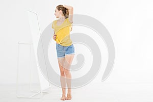 Girl dress up and looking in mirror. Shopping and weight loss concept. Copy space. Blank template background.