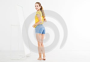 Girl dress up and try on clothes looking in mirror. Shopping and weight loss concept. Copy space. Blank template background. Body