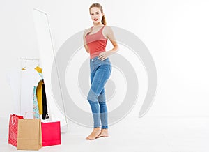 Girl dress up and try on clothes looking in mirror. Shopping and weight loss concept. Copy space. Blank template background. Body