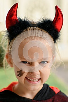 A girl dressed as a devil with horns