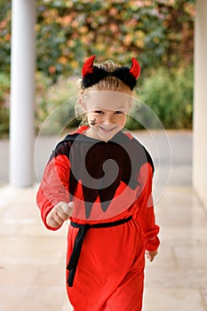 A girl dressed as a devil with horns