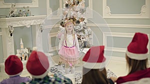 Girl dressed as fairy waving a magic wand. Little girl dancing in front of the audience.