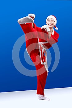 A girl dressed as Santa Claus doing karate kick