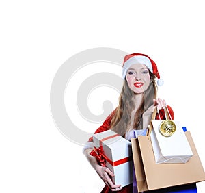 Girl dressed as Santa with holiday shopping bags and gift box on white background isolated. Christmas, New Year concept