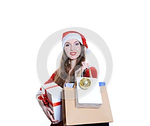 Girl dressed as Santa with holiday shopping bags and gift box on white background isolated. Christmas, New Year concept