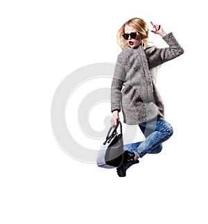 Girl dressed in grey fur coat, wearing sunglasses and black bag, posing on white background. Beauty Fashion Blond.