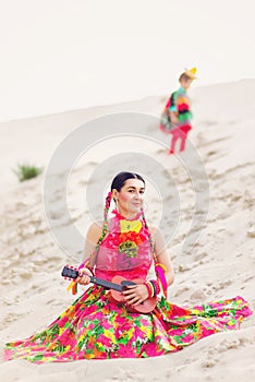 Girl dressed in a Mexican outfit and playing