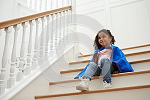 Girl Dressed Up As Superhero Playing Game On Stairs