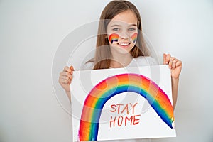Girl drew rainbow and poster stay home.