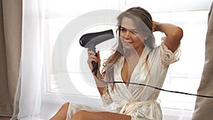 Girl dries hair with a hair dryer