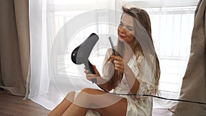Girl dries hair with a hair dryer