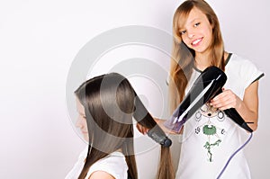 Girl dries hair the hair dryer other teen girl