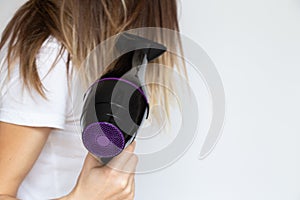 The girl dries her hair with a hairdryer on a white background, hair dryer and hair