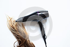 The girl dries her hair with a hairdryer on a white background, hair dryer and hair