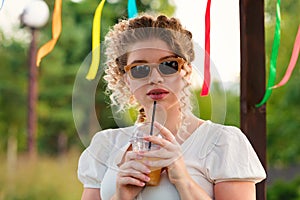 Girl with drink outdoors