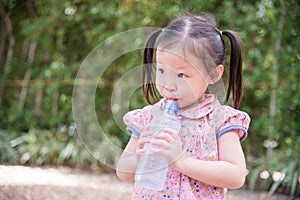 Girl drink water from bottle by straw