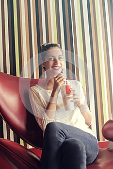 Girl drinking on a chair