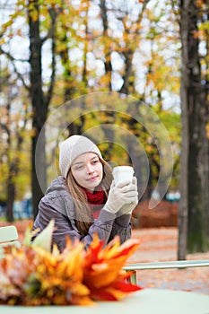 Girl drinking coffee in an outdoor Parisian cafe