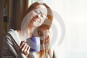 Girl drinking coffee or tea in morning sunlight