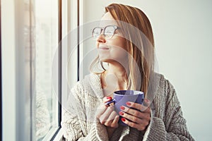 Girl drinking coffee or tea in morning sunlight