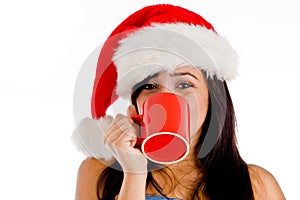 Girl drinking coffee wearing christmas hat